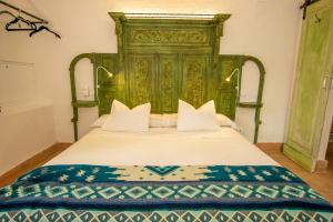 a green bed with a green headboard in a room at Apartamentos Sharis in Jerez de la Frontera