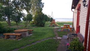 un patio trasero con parque infantil y estructura de juegos en Laucinieki en Mākoņkalns