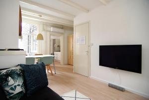 een woonkamer met een flatscreen-tv aan de muur bij Loft Leidsegracht in Amsterdam