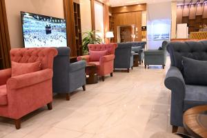 a waiting room with chairs and a flat screen tv at جوهرة السراة للأجنحة الفندقية in Khamis Mushayt