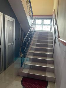 eine Treppe in einem Haus mit einer Tür und einem roten Teppich in der Unterkunft Complexe Meublé PEPON in Douala
