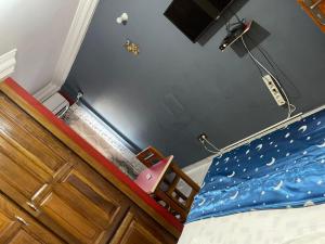 a bedroom with a bed with a blue comforter at Complexe Meublé PEPON in Douala