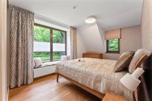 1 dormitorio con cama y ventana grande en Apartment Adélka 203 - Residence Koubek en Špindlerův Mlýn