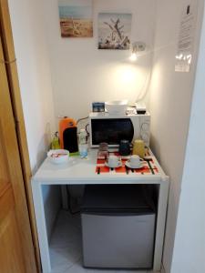 a small kitchen with a stove and a microwave at La Casa di Berenice a Porto Azzurro in Porto Azzurro