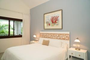 a white bedroom with a bed and a window at Hotel Casa Hemingway in Juan Dolio