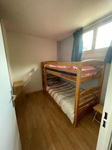 two bunk beds in a small room with a window at Le Seignus d'Allos T2 30m2. Aux pieds des pistes. in Allos