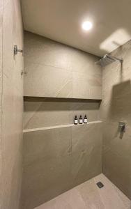 y baño con ducha y 3 botellas en un estante. en D201 Ocean View New 2 Bedroom Apartment - Punta Cocos en Holbox Island