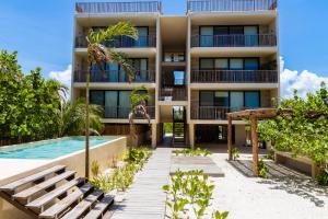 um edifício de apartamentos com uma piscina e um resort em D201 Ocean View New 2 Bedroom Apartment - Punta Cocos em Holbox