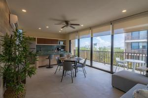 a living room with a table and chairs and a balcony at D201 Ocean View New 2 Bedroom Apartment - Punta Cocos in Holbox Island