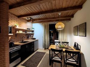 a kitchen with a table and chairs and a kitchen with a stove at Apartmani Pahulja in Jahorina