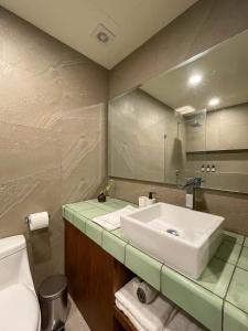 uma casa de banho com um lavatório, um WC e um espelho. em D201 Ocean View New 2 Bedroom Apartment - Punta Cocos em Holbox