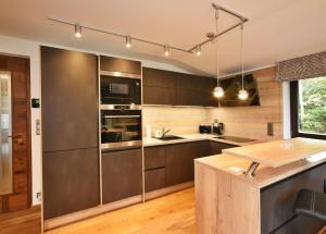 a kitchen with stainless steel appliances and a wooden counter at Apartment Adélka 203 - Residence Koubek in Špindlerův Mlýn