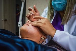 un médico que realiza un procedimiento en la cara de un paciente en Hotel Matamundo en Neiva