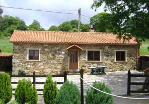 a stone house with a table in front of it at Stone Cottage FISTERRA in Curtis
