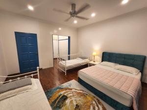 a bedroom with two beds and a ceiling fan at Solok Burma Vacation Home @ Gurney Penang in George Town