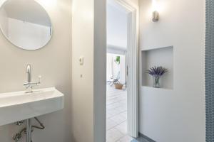 La salle de bains est pourvue d'un lavabo et d'un miroir. dans l'établissement Strandkoje Wohnung 7, à Rettin
