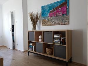 a living room with a book shelf with books at Gruga Apartment an der Messe in Essen
