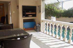 a patio with a table and a balcony at Bougainvillea at Boskruin in Johannesburg