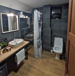 a bathroom with two sinks and a toilet and a shower at Apartmani Pahulja in Jahorina