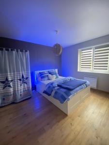 a bedroom with a bed with a blue ceiling at Maison familiale 152m2 à 10 minutes de Colmar in Wintzenheim