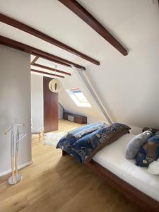 a attic bedroom with a bed and a staircase at Maison familiale 152m2 à 10 minutes de Colmar in Wintzenheim