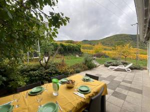 a table with a yellow table cloth on a patio at Maison familiale 152m2 à 10 minutes de Colmar in Wintzenheim