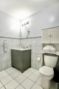 ein Badezimmer mit Toilette, Waschbecken und Spiegel in der Unterkunft Urban Oasis Spacious 3BR 2BA Patio Near NYC EWR American Dream Mall in Newark + 19 Fotos