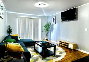 ein Wohnzimmer mit einem blauen Sofa und einem Tisch in der Unterkunft Urban Oasis Spacious 3BR 2BA Patio Near NYC EWR American Dream Mall in Newark