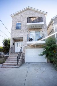 ein Backsteinhaus mit einer weißen Garagentür und einer Treppe in der Unterkunft Urban Oasis Spacious 3BR 2BA Patio Near NYC EWR American Dream Mall in Newark