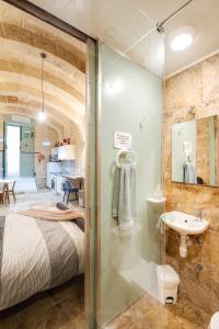 a bathroom with a bed and a sink in a room at MCC Suites Valletta in Valletta