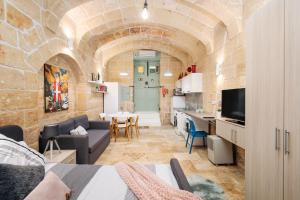 a living room with a couch and a dining room at MCC Suites Valletta in Valletta
