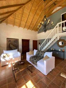 a living room with a white couch and stairs at Barrel House Suite St Eustatius in Oranjestad