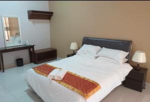 a bedroom with a large bed with two towels on it at Labuan Paragon Apartment - 3 rooms in Labuan