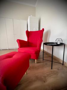 una silla roja y una mesa en una habitación en Nocleg Opole Kopernik Apartament, en Opole