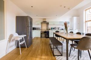a kitchen and dining room with a table and chairs at The Clapham Dream - Captivating 3BDR with Garden & Parking in London