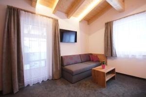 Una sala de estar con un sofá y una ventana. en Alpin Juwel Apartments, en Galtür