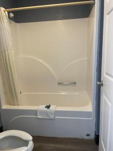 a bathroom with a white tub and a toilet at Deerfield Inn in Adamsville