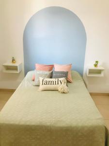 een bed met veel kussens erop bij Departamento luminoso y céntrico in Santiago del Estero
