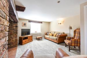 a living room with a couch and a tv at Dovecote Farm House in Goole