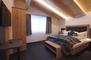 Un dormitorio con una cama grande y una ventana en Alpin Juwel Apartments, en Galtür