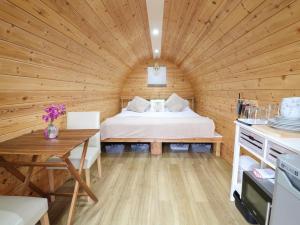 a bedroom in a log cabin with a bed in it at The Pod at Bank House Farm in Stafford +5 photos
