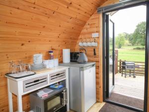 a kitchen with a stove and a door to a patio at The Pod at Bank House Farm in Stafford