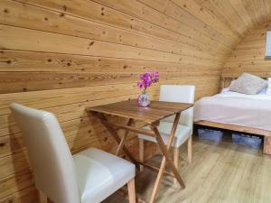 a wooden room with a table and two chairs and a bed at The Pod at Bank House Farm in Stafford