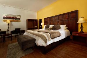 a hotel room with a large bed and a chair at Casa de Avila in Arequipa