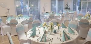 a room with white tables and chairs with flowers on them at Zur Linde in Mainzweiler