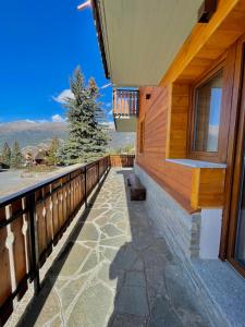 uma varanda de uma casa com vista para as montanhas em Case Vacanza Perron em Sauze dʼOulx