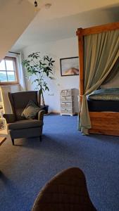 ein Wohnzimmer mit einem Sofa, einem Bett und einem Stuhl in der Unterkunft Gemütliche Waldrandlage in Badenweiler Sehringen Ferienwohnung in Badenweiler