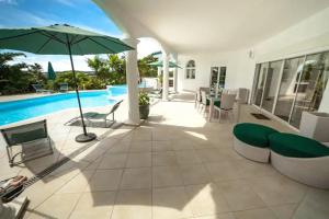 une terrasse avec un parasol et une piscine dans l'établissement Villa Millésime, au François