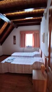- une chambre avec un grand lit dans une pièce dotée d'une fenêtre dans l'établissement Casa Gonano, à Prato Carnico