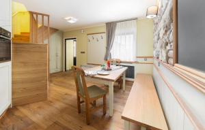a dining room with a table and a kitchen at Apartma Rozika in Ptuj